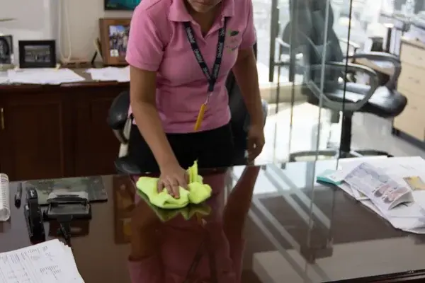 Colaboradora de LIMPSA limpiando el escritorio de una oficina